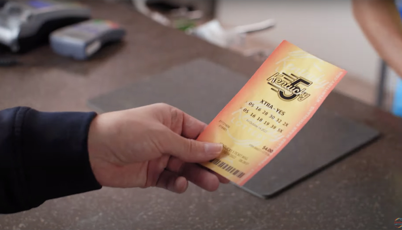 A hand, holding a Kentucky 5 ticket.