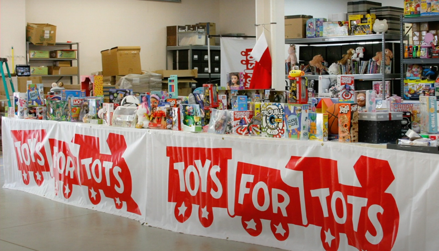 A table filled with donated toys during a Toys for Tots toy drive.