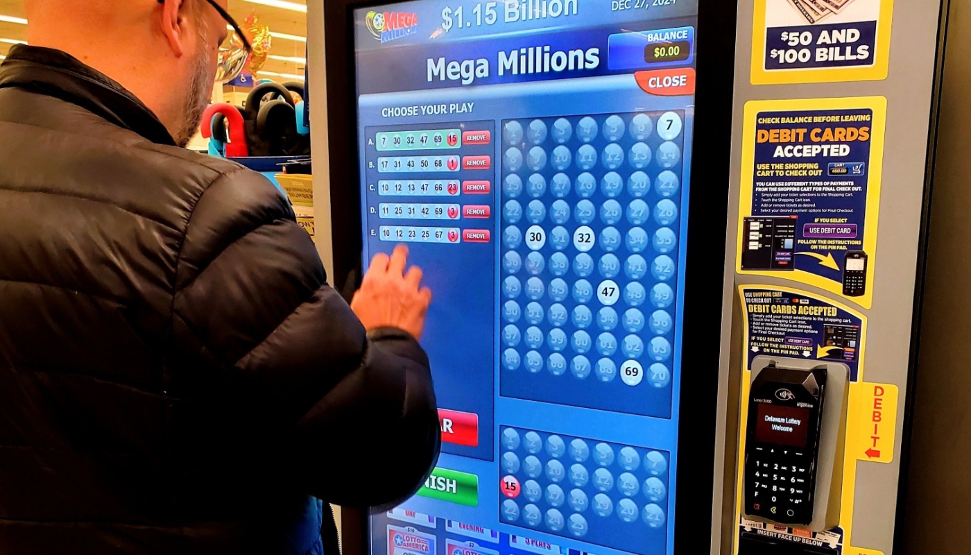 A lottery player using a lottery ticket machine to play Mega Millions.