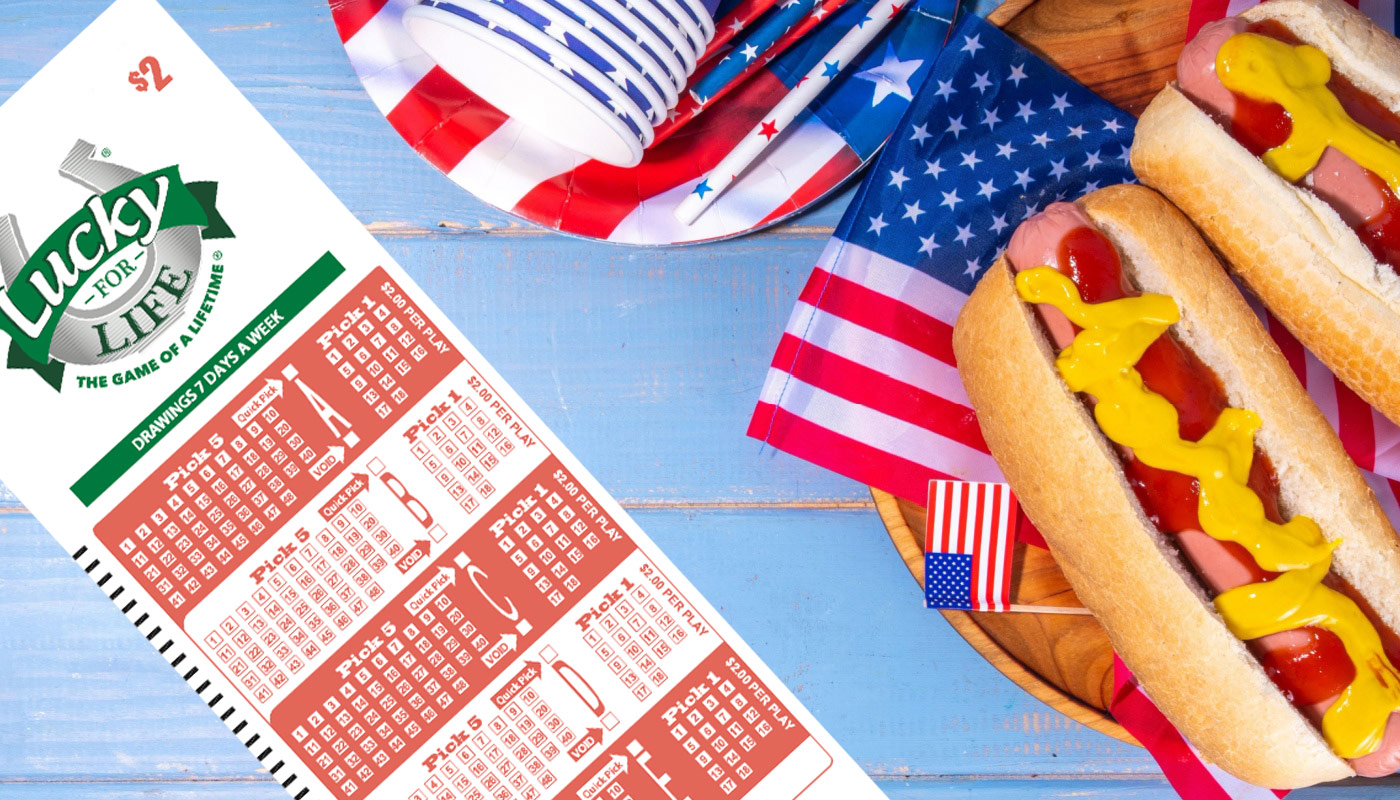 A table with hotdogs, american flags, and a Lucky for Life play slip.