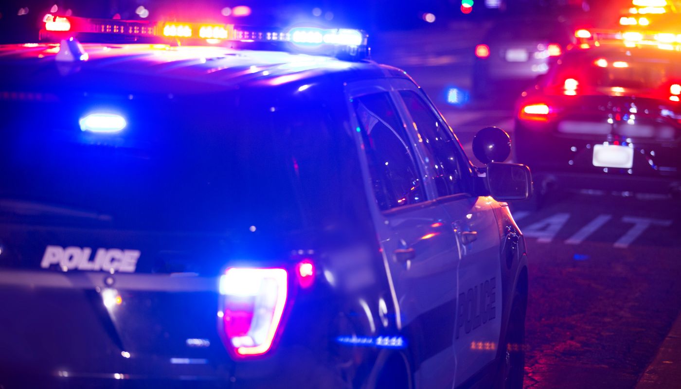 A police car with flashing lights at night.