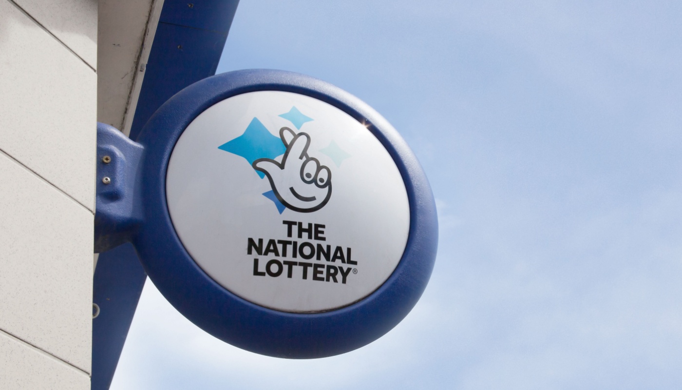 A UK National Lottery sign at a lottery retailer.