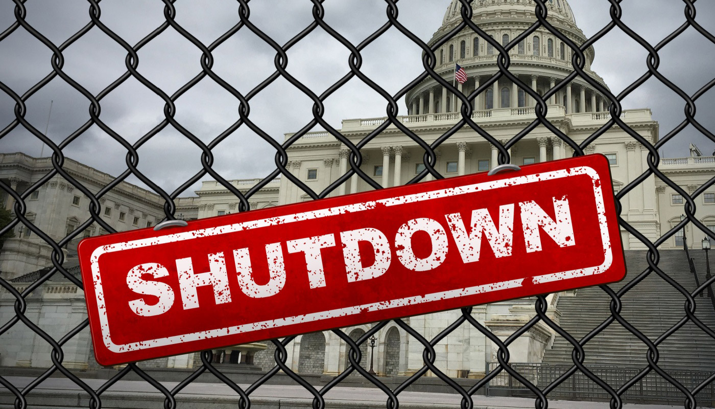 The United States Capitol behind a fence with the word "Shutdown" over it.