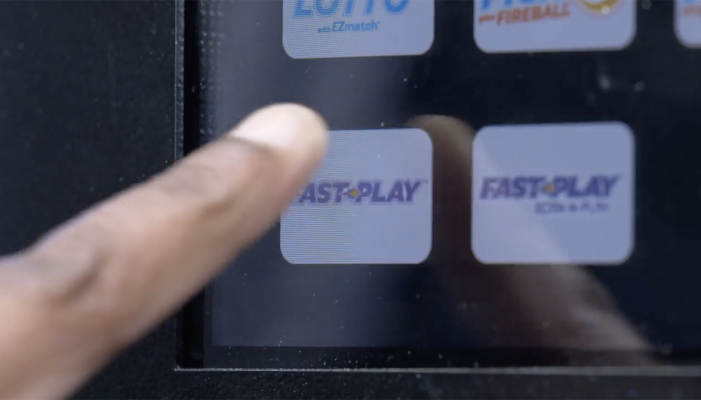 A finger pressing "Fast Play" on a touch screen.