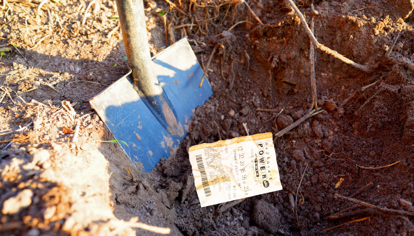 A hole in the dirt with a Powerball ticket and a shovel.