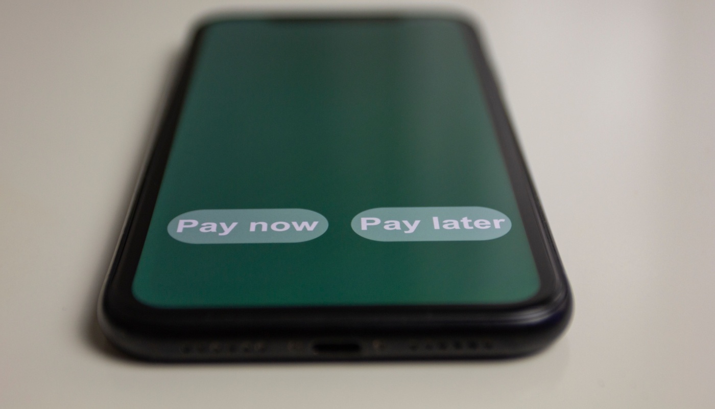 A mobile device displaying two options: Pay now or pay later.