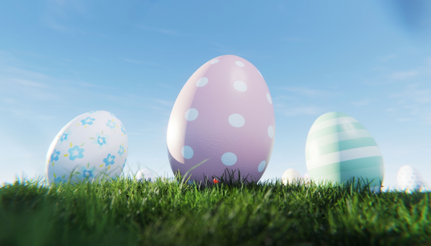 Three easter eggs on an open field with blue sky.