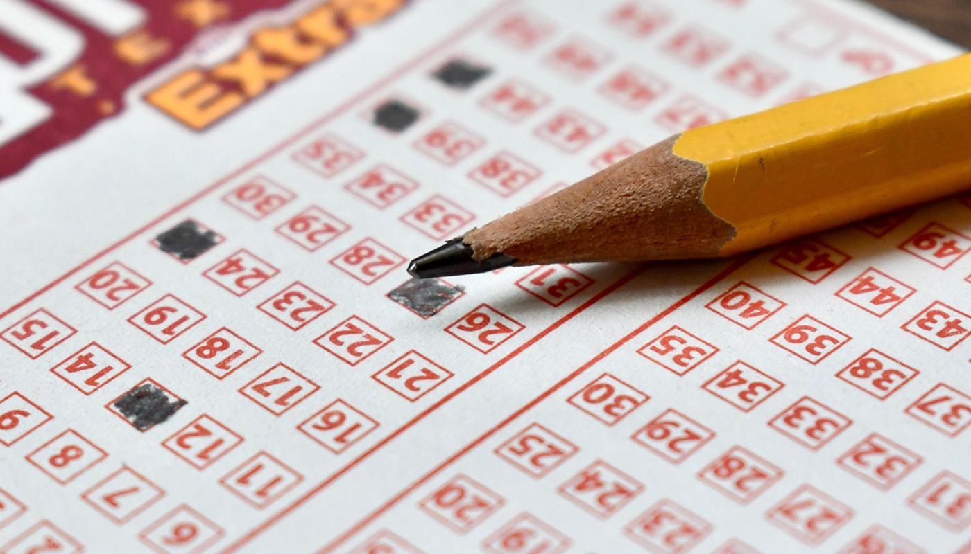 A pencil over a filled out lottery play slip.