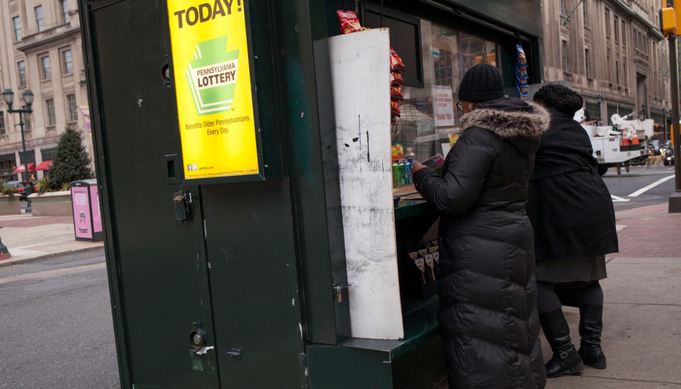 People queuing at a local retailer in Pennsylvania, with a Pennsylvania Lottery sign on the side.