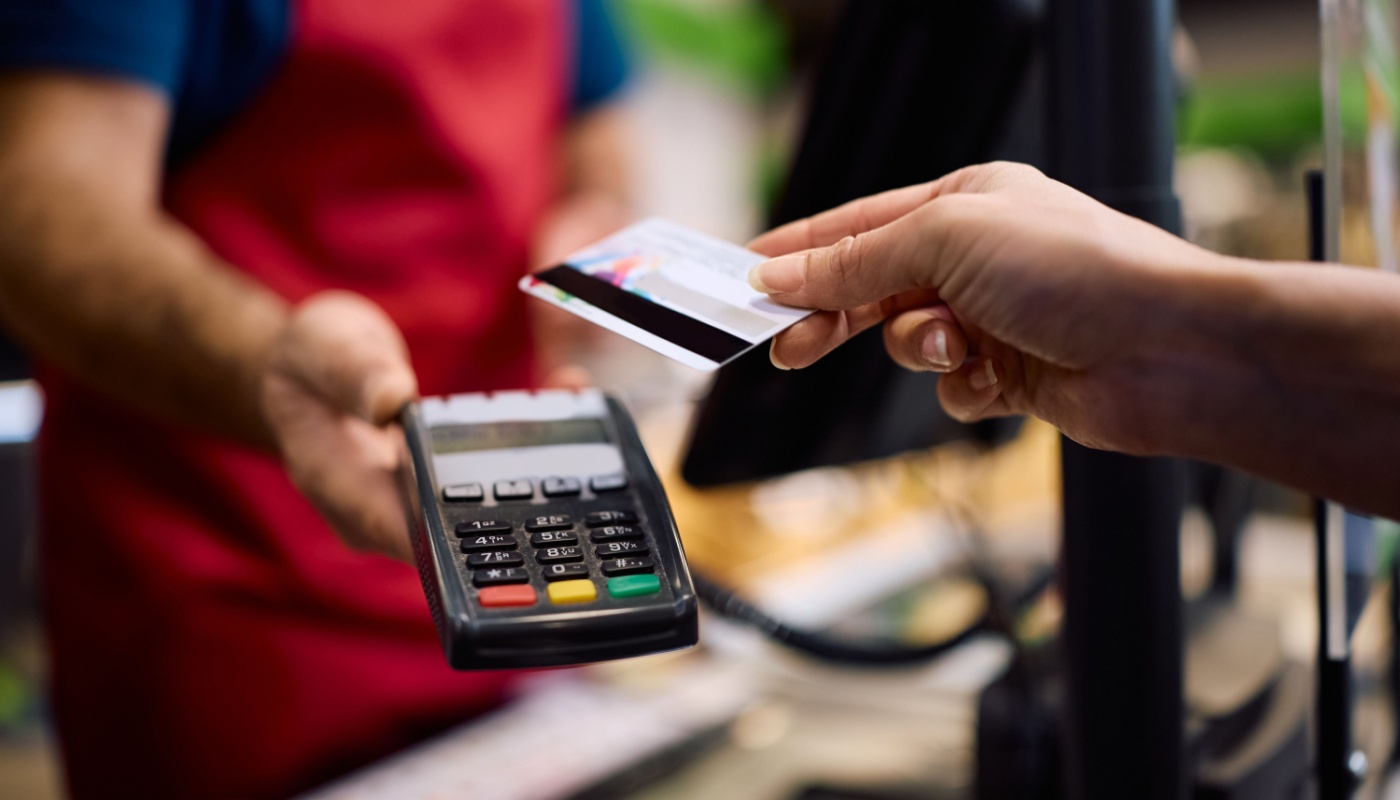 A person using a debit card to pay at a local retailer.