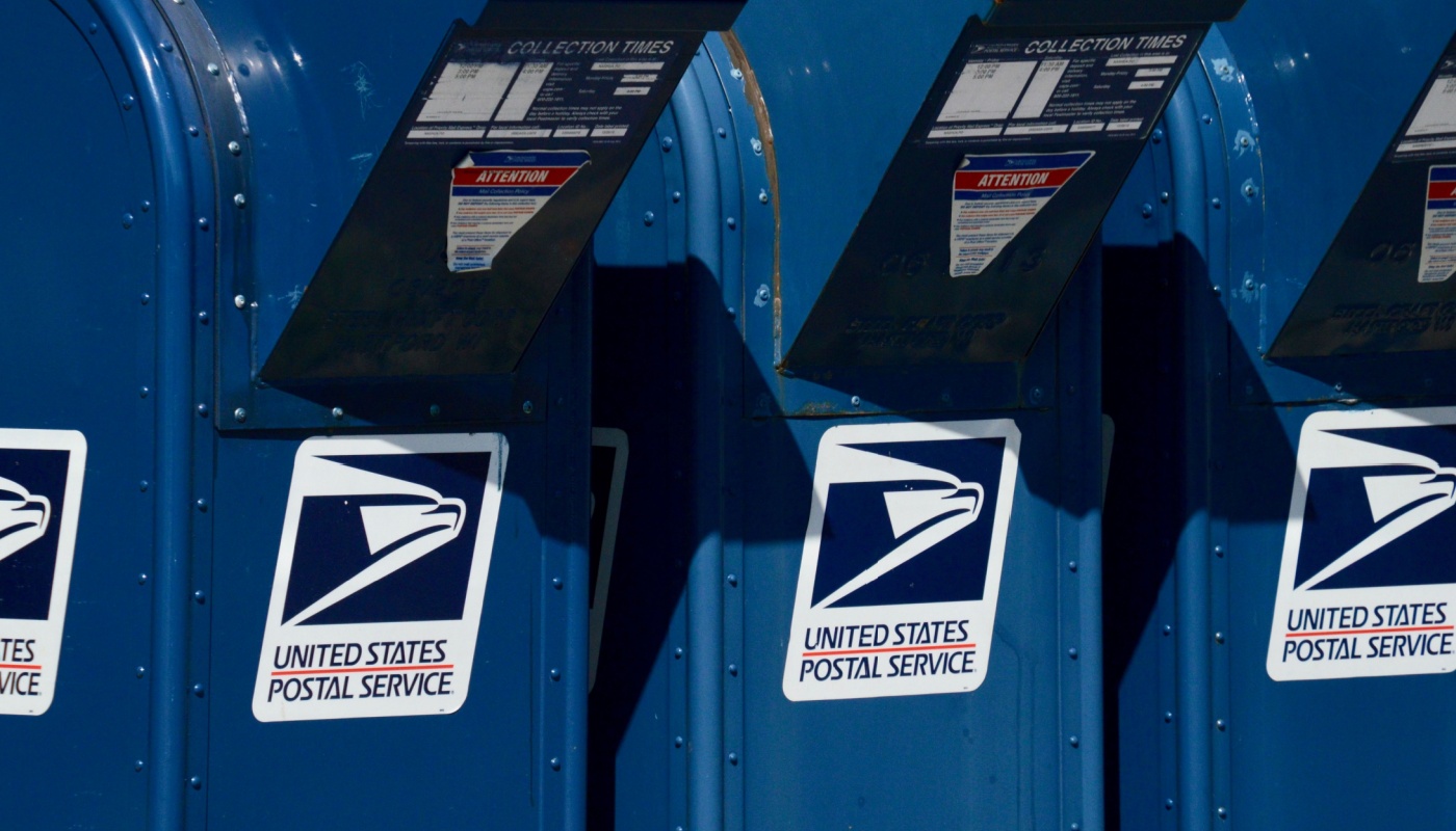 Three USPS mailboxes at curbside.
