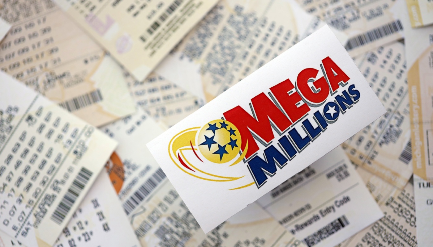 The Mega Millions logo on a sticker, over several lottery tickets.