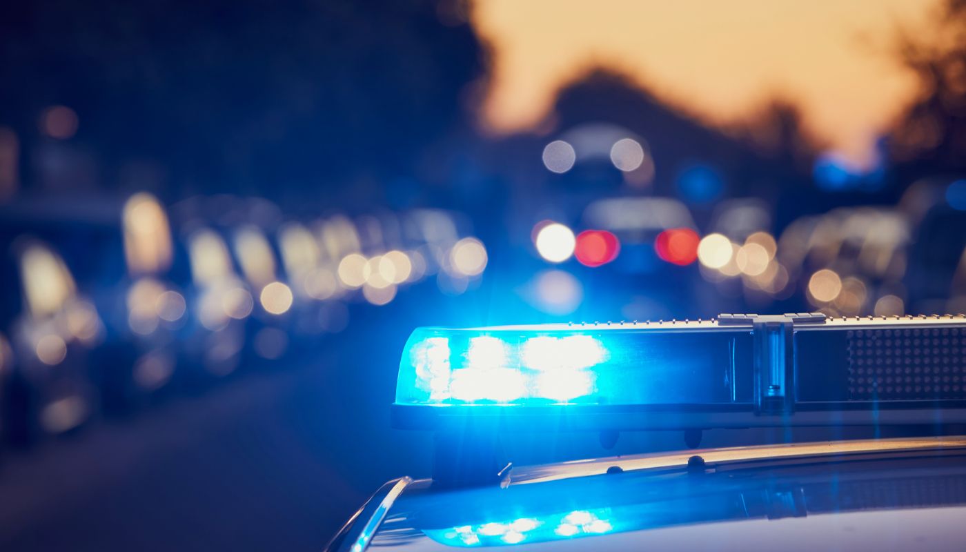 The top of a police car at dusk, with it's lights turned on.