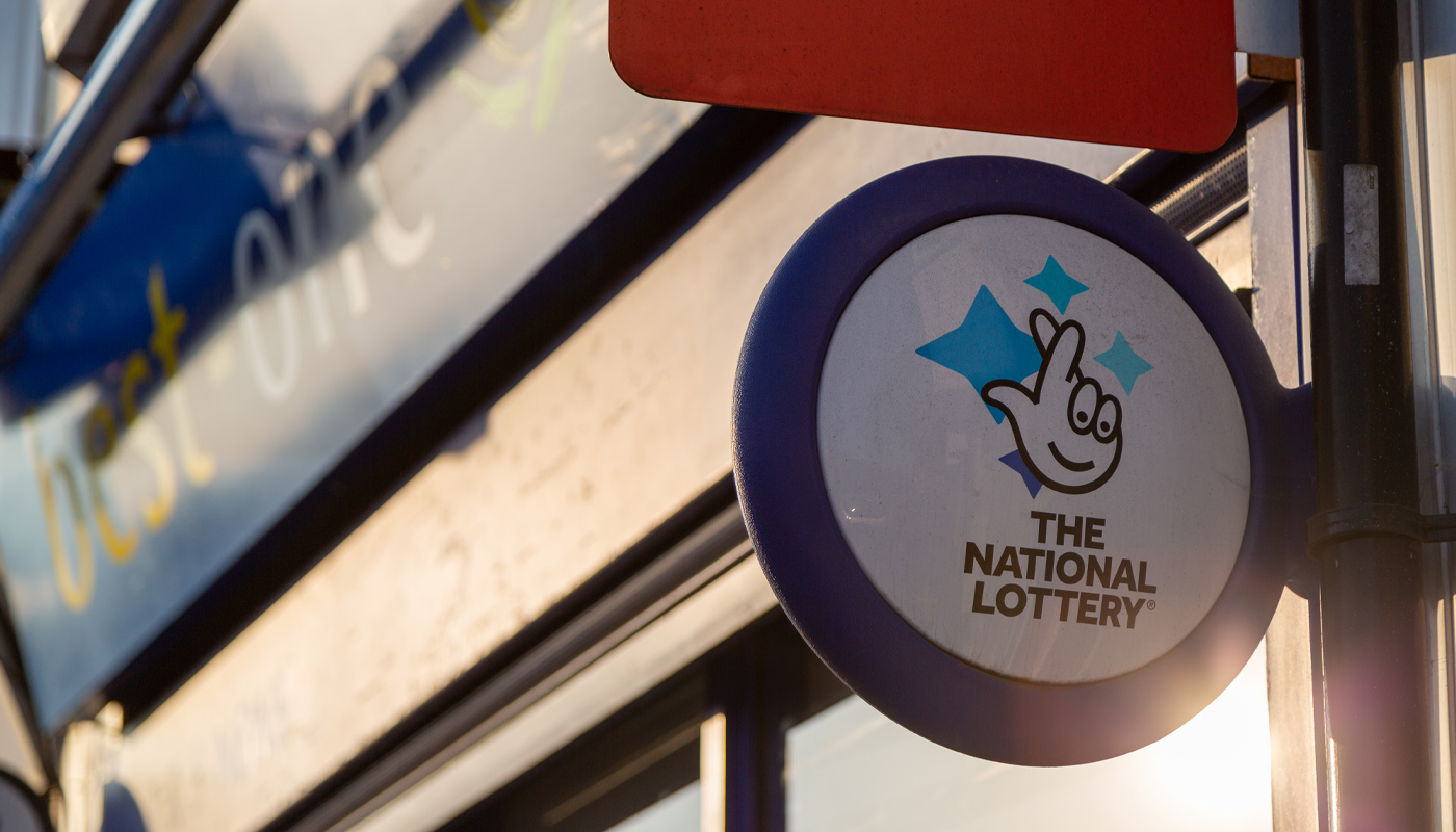 A UK National Lottery sign at a local lottery retailer.