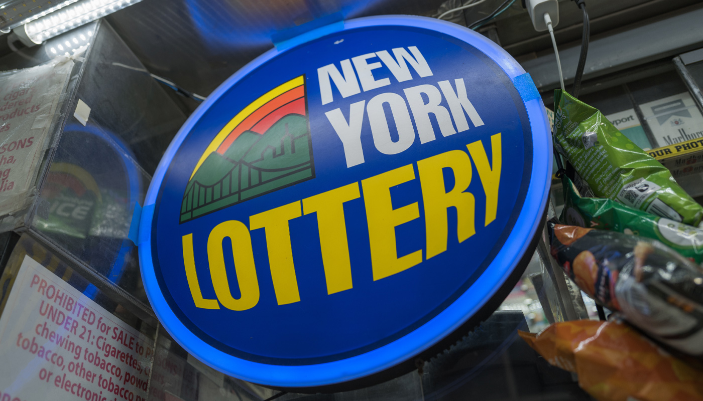 A New York Lottery sign on the window of a lottery retailer.