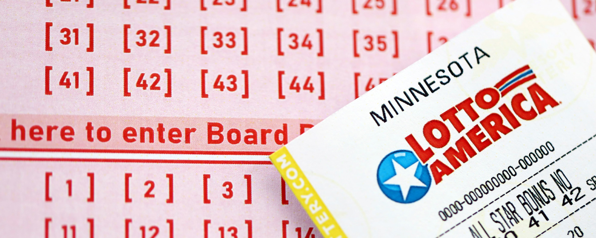 A Lotto America ticket over a playslip.